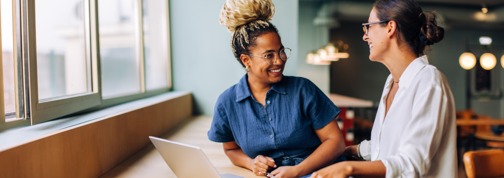 two colleagues having friendly conversation in office